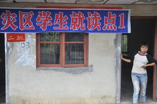 7月1日,一名學(xué)生站在災(zāi)區(qū)學(xué)生就讀點(diǎn)的教室前。新華社記者 歐東衢 攝