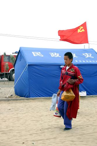 7月11日,在格爾木洪水災區(qū)安置點,一個男孩領取食物和開水后,返回自家?guī)づ?。記者從青海省格爾木市防汛抗洪指揮部獲悉,在各級政府的有效組織下,格爾木市已有9000余名群眾安全疏散轉移,并得到妥善安置。近期格爾木市持續(xù)出現較強降水過程,呈現來勢猛、強度大、致災成因強等顯著特點,導致山洪暴發(fā)、多處引水渠道和水利設施被毀,溫泉水庫、格爾木河出現重大險情,群眾生命財產受到嚴重威脅。新華社記者 何偉 攝