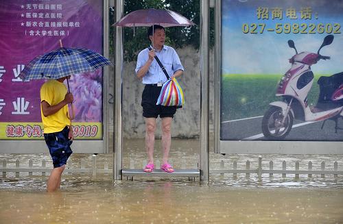7月13日,市民在武漢市江夏區(qū)文化路的公交車站等車。據(jù)湖北省氣象部門發(fā)布的信息,7月7日8時到13日15時,江夏、洪湖、英山、羅田累計雨量超過500毫米,其中江夏、洪湖分別為547毫米和537毫米,歷史罕見。在降雨量最集中的7月8日至12日5天時間里,與歷史任意5天暴雨過程累計雨量相比,洪湖、英山、江夏、赤壁、羅田、嘉魚累計降雨量排前四位,其中江夏創(chuàng)歷史任意5天過程雨量極值。新華社發(fā)(鄒祖虎 攝)