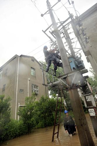 7月13日,武漢市江夏區(qū)供電部門緊急調派搶修隊伍,冒雨鋪設200多米的電纜線路,從法泗街衛(wèi)東村的公用變壓器將電源接到泵站,恢復備用機組排澇。新華社發(fā)(鄒祖虎 攝)