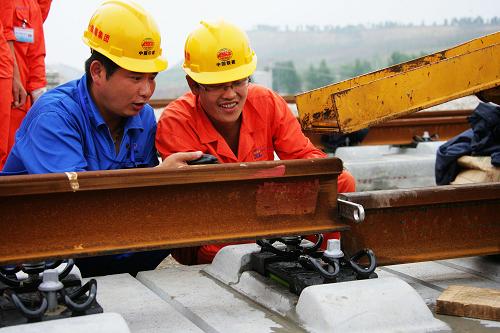 7月17日,中國鐵建十四局集團京滬高鐵項目部的工程技術(shù)人員正在精確對接500米長軌。新華社發(fā)(劉文攝)