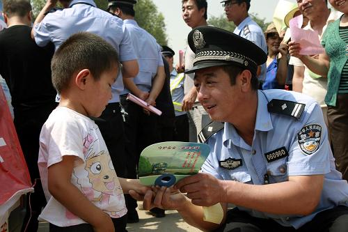 8月3日,一名太原鐵警向兒童發(fā)放《鐵路法》宣傳用品。新華社發(fā)(梁敬 攝)
