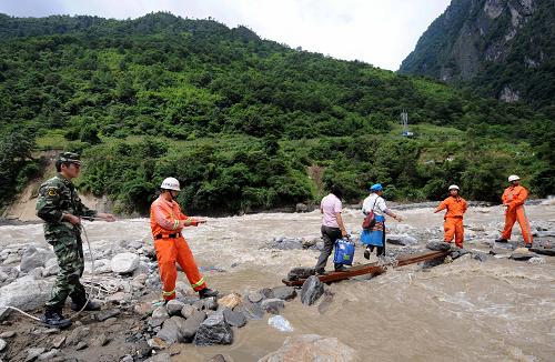 8月19日,救援人員在怒江邊的云南貢山普拉底鄉(xiāng)幫助當?shù)厝罕姲踩^河。新華社記者 藺以光 攝