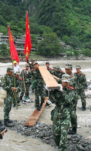 8月18日,在云南貢山山洪泥石流災(zāi)區(qū),武警官兵設(shè)法用木板鋪設(shè)簡(jiǎn)易通道。新華社發(fā)(程慶祥 攝)