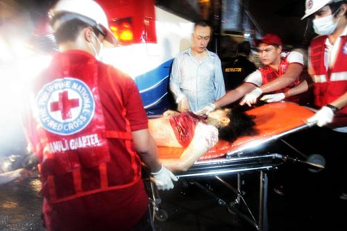 8月23日,在菲律賓首都馬尼拉,醫(yī)護人員把傷者抬上救護車。一輛中國香港旅游團大客車當日在馬尼拉被劫持,共有7名人質(zhì)死亡、2名人質(zhì)重傷、6名人質(zhì)輕傷,另外10名人質(zhì)獲釋。 新華社發(fā)