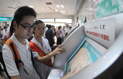 9月8日,長沙市民在湘雅二醫(yī)院門診大廳自助終端前試用“長城建康卡”預(yù)約掛號。新華社記者 龍弘濤 攝