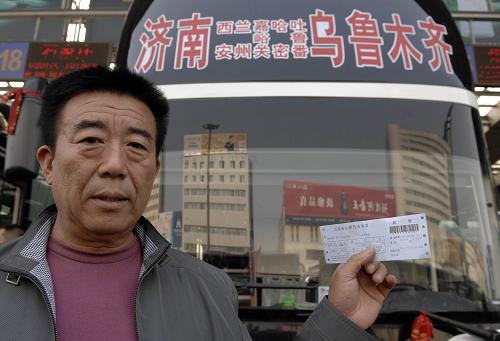 10月6日,在濟(jì)南市廣場(chǎng)汽車站,辛建華拿著車票成為濟(jì)南至烏魯木齊長(zhǎng)途巴士的第一位乘客。新華社記者 郭緒雷 攝