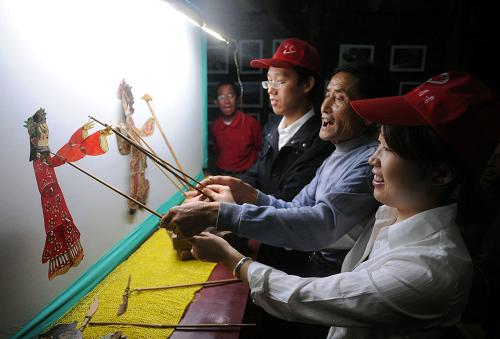 宣城“宛陵陽(yáng)光”青年志愿者徐金棟(右三)、夏麗妮(右)與皮影戲老藝人(中)一道給孩子們表演皮影戲(10月12日攝)。為豐富鄉(xiāng)村留守兒童的學(xué)習(xí)生活,安徽省宣城市水東鎮(zhèn)皖南皮影博物館與宣城電力“宛陵陽(yáng)光”青年志愿者共同發(fā)起“皮影進(jìn)鄉(xiāng)村”活動(dòng),將皮影戲這項(xiàng)有著“世界最古老電影”之稱的民間藝術(shù),傳播給農(nóng)村的孩子們。新華社記者 王雷 攝