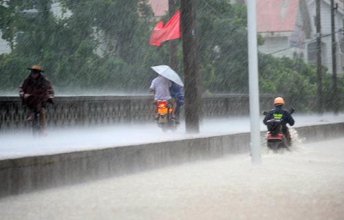 10月16日晨,海南瓊海市街頭積水嚴(yán)重,市民冒雨艱難出行。新華社發(fā)(蒙鐘德 攝)