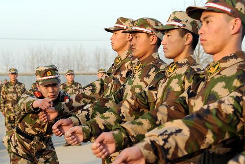 12月16日,河北省公安邊防總隊新訓(xùn)團一位班長在給新兵糾正擺臂練習(xí)動作。新華社記者 楊世堯 攝