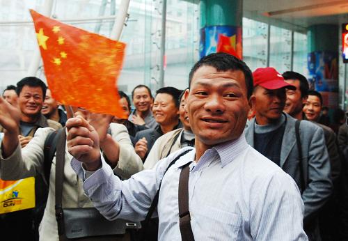 3月3日,在江西南昌火車(chē)站出口處,從利比亞撤至埃及回國(guó)的江西南昌籍工人向迎接的人們揮舞國(guó)旗。新華社發(fā)(胡國(guó)林 攝)
