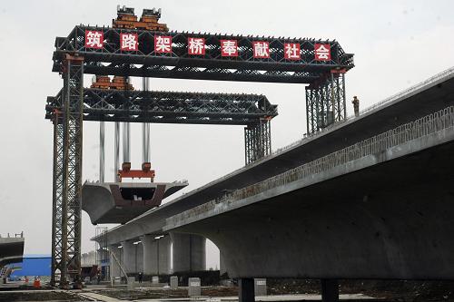 3月2日,在寧安城際鐵路安徽蕪湖段工地,提梁機架設(shè)750噸高鐵雙線箱梁。新華社發(fā)(陳立希 攝)