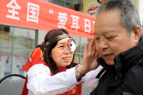 3月3日,志愿者王惠(左)在為社區(qū)老人進行耳部健康檢查。當日,青島市殘聯(lián)組織志愿者舉行“愛耳日”關(guān)愛老人活動,為年滿60歲的市民免費進行聽力篩查,建立聽力健康檔案,并將社會愛心捐贈的助聽器配送給家庭困難的聽障老人。新華社記者 李紫恒 攝