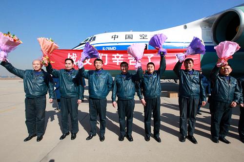 3月4日,圓滿完成運輸任務的空軍運輸機機組人員向歡迎人群致意。新華社記者 查春明 攝