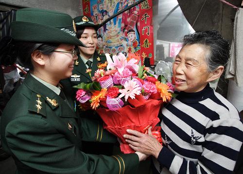 遼寧邊防總隊(duì)營(yíng)口邊防檢查站干部張?jiān)拢ㄗ螅?、生明月(中)等官兵帶著康乃馨等禮物走訪慰問駐地78歲的“兵媽媽”鄒惠芬(5月4日攝)。新華社發(fā)(張鵬 攝)