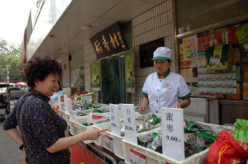 5月26日,一位顧客在北京稻香村一家門店前選購(gòu)粽子。老字號(hào)稻香村散售的小棗、豆沙粽從去年每袋(2個(gè))6元漲至8元;蛋黃鮮肉粽也從每袋8元漲到了10元。新華社記者 趙琬微 攝