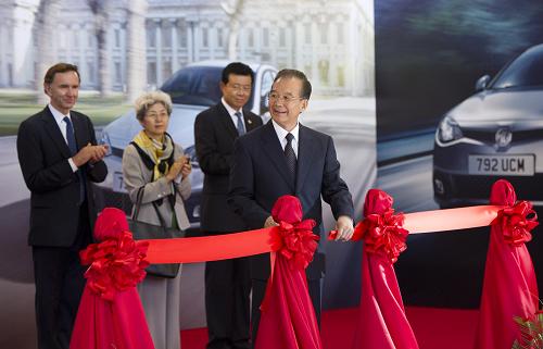 6月26日,國務(wù)院總理溫家寶在英國伯明翰視察MG汽車英國有限公司。這是溫家寶為MG6新車下線剪彩。新華社記者 黃敬文 攝