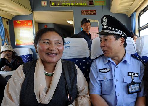 乘警與藏族牧民在火車上拉家常(6月17日攝)。新華社記者 覺果 攝