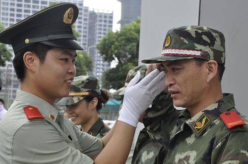 6月28日,福州邊防戰(zhàn)士為角色互換的陳文君老師(右)糾正敬禮姿勢。新華社發(fā)(孫旭暉 攝)