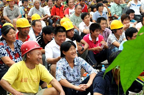 7月17日,來自河南新蔡縣的在京務(wù)工人員開心地觀看孩子們的慰問演出。新華社發(fā)(趙學(xué)風(fēng) 攝)