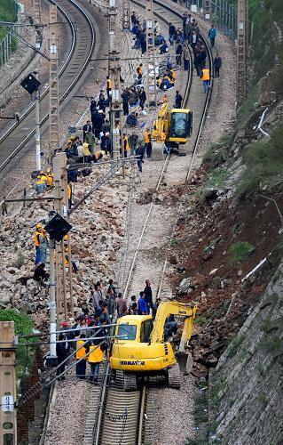 9月19日,施工人員在搶修隴海鐵路三門峽市境內(nèi)溜塌的鐵路護坡。從鄭州鐵路局了解到,因近期連續(xù)降雨,18日晚隴海鐵路下行線河南三門峽市境內(nèi)觀音堂車站至廟溝車站間因水害塌方中斷行車,造成部分旅客列車晚點、滯留。鄭州鐵路局在全力搶險的同時,及時采取“反方向”行車(即組織下行列車在觀音堂-廟溝上行線反方向運行)、停開貨車等應(yīng)急措施,保證客車通行。由于此處水害受地形和水害情況限制,搶險難度非常大,鐵路部門正在全力以赴,力爭盡快開通。新華社發(fā)(高山岳 攝)