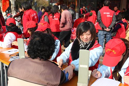 12月5日,上海崇明縣的青年志愿者在為居民做健康檢查。新華社發(fā)(張峰 攝)