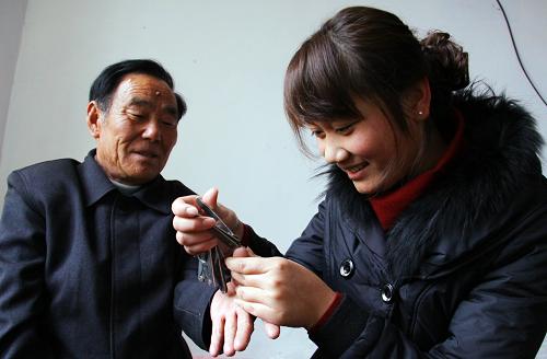 12月5日,山東省棗莊市山亭區(qū)水泉鎮(zhèn)大學(xué)生村官佘彬彬(右)為孤寡老人剪指甲。新華社發(fā)(劉明祥 攝)