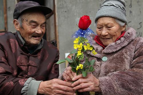 2月14日,楊志昌(左)為老伴楊淑芝獻(xiàn)上鮮花。新華社發(fā)(姚永亮 攝)