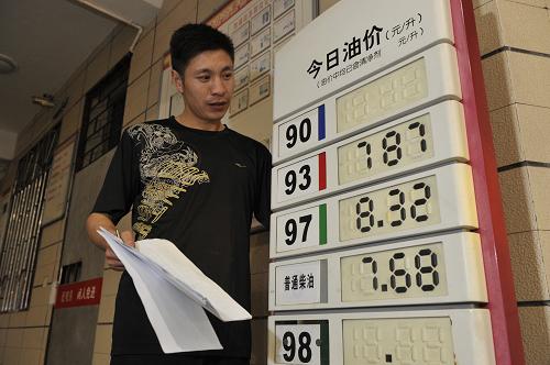 5月10日凌晨,加油站工作人員在貴陽一家加油站內(nèi)調(diào)整價(jià)目表。新華社記者 歐東衢 攝