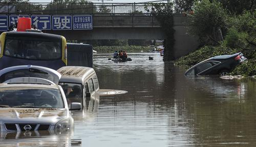 7月22日,搜救人員在淹沒的車輛間搜索。新華社記者 張宇 攝