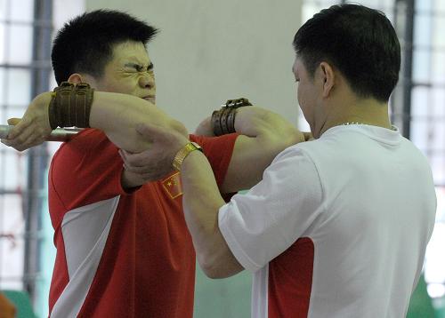 這是2011年4月12日,中國(guó)舉重隊(duì)隊(duì)員林清峰(左)在亞洲舉重錦標(biāo)賽期間,在教練的指導(dǎo)下訓(xùn)練。新華社記者 郭晨 攝