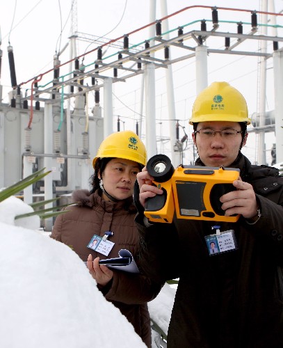 1月29日,安徽省淮北供電公司員工在用紅外測溫儀測量溫度變化。新華社發(fā)(王文 攝)