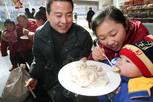1月30日,一對(duì)準(zhǔn)備乘車返鄉(xiāng)的農(nóng)民工夫婦和孩子一起吃上濟(jì)南長(zhǎng)途客運(yùn)中心站送的水餃。當(dāng)日是農(nóng)歷臘月二十三,也是俗稱的“小年”。濟(jì)南長(zhǎng)途客運(yùn)中心站開展“送福送吉祥 溫馨過(guò)‘小年’”活動(dòng),讓準(zhǔn)備乘車返鄉(xiāng)的農(nóng)民工吃上熱騰騰的免費(fèi)水餃,并送上“福”字和春聯(lián),在車站里度過(guò)一個(gè)溫馨快樂(lè)的“小年”。 新華社發(fā)(呂傳泉 攝)