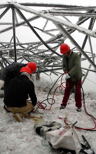 1月31日,在貴州龍里縣的一條因雪凝災害造成的220千伏安輸電線路損毀現(xiàn)場,南方電網(wǎng)公司貴陽供電局的搶險人員正在重建電塔。 近新華社記者 楊楹 攝