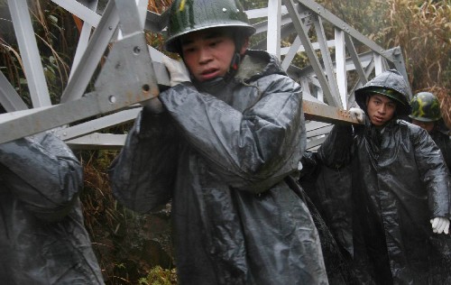 2月1日,武警南平支隊(duì)官兵冒雨將電力設(shè)備抬往鷹廈鐵路邵武區(qū)段供電線路故障現(xiàn)場搶修點(diǎn)。新華社發(fā)(林傳仁 攝)