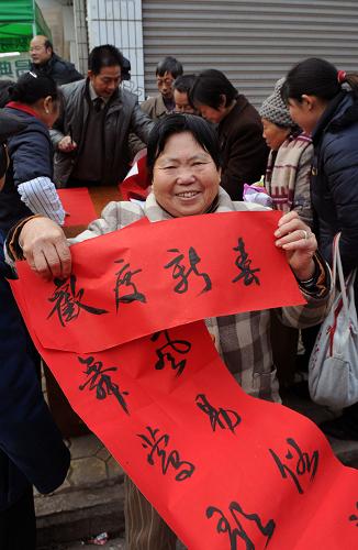 1月6日,四川西充縣多扶鎮(zhèn)一位婦女展示“三下鄉(xiāng)”小分隊書法家給她寫的春聯(lián)。 當日,四川省南充市2009年文化、科技、衛(wèi)生“三下鄉(xiāng)”活動在西充縣多扶鎮(zhèn)啟動,受到當?shù)厝罕姷臍g迎。 新華社發(fā)(成潮生 攝)