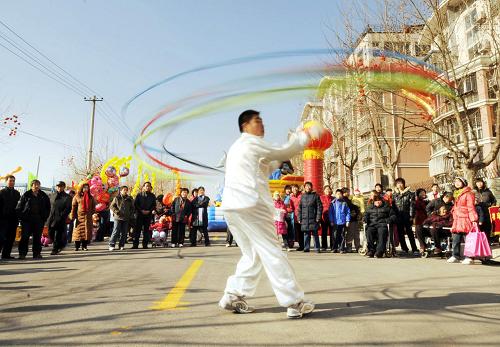 1月18日,一名民間藝人為游客表演“呼啦圈空竹”。 當(dāng)日,為期3天的北京市朝陽(yáng)區(qū)南磨房鄉(xiāng)第二屆民俗文化節(jié)開幕,吸引眾多市民來看表演、品小吃、購(gòu)年貨。 新華社發(fā)(鄭永 攝)