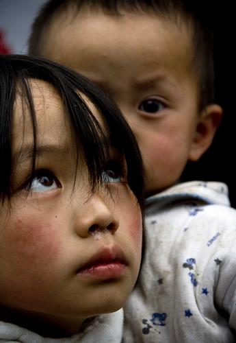 2008年5月24日,在四川北川縣北川中學(xué)受災(zāi)群眾臨時安置點,10歲的王永霞(前)和1歲8個月大的王莉郡在一起。 新華社發(fā)