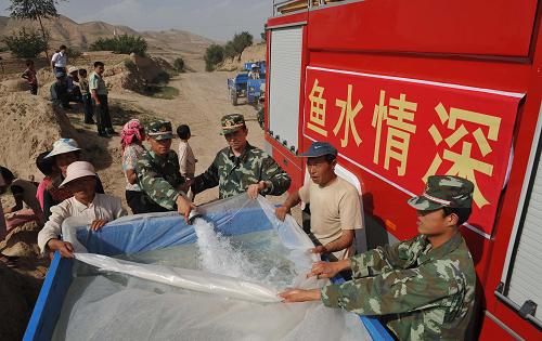 8月14日,消防官兵為寧夏西吉縣田坪鄉(xiāng)藍岔村村民開箱灌水。 地處寧夏中部干旱帶的西吉縣十年九旱,當?shù)剞r(nóng)民靠天吃飯,生產(chǎn)生活條件惡劣。最干旱的田坪鄉(xiāng)連續(xù)8年受旱災,持續(xù)200多天沒有出現(xiàn)有效降水,人畜飲水極其困難。寧夏消防總隊西吉縣中隊得知情況后,主動與當?shù)卣?lián)系,為群眾義務送水。 新華社記者 劉泉龍 攝