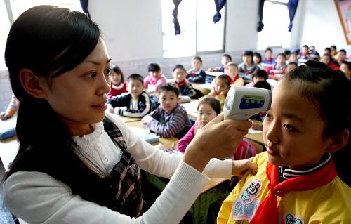 11月3日,剛復(fù)課的四川華鎣市雙河小學(xué)學(xué)生在課間接受體溫檢測。新華社發(fā)(邱海鷹 攝)