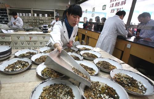 11月5日,在江蘇省泰州市中醫(yī)院,藥劑師按照預(yù)防甲型H1N1流感中藥處方配藥。 近日,泰州市中醫(yī)院根據(jù)國(guó)家衛(wèi)生部提供的預(yù)防甲型H1N1流感的處方,結(jié)合泰州地區(qū)人群的特點(diǎn),擬定出防治甲流的“本土方子”,不少市民前去醫(yī)院配制中藥方劑預(yù)防甲流。 新華社發(fā)(顧俊 攝)