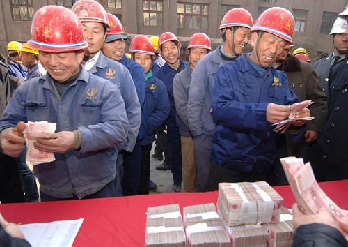 2007年11月18日,在烏魯木齊市帝王大廈封頂現(xiàn)場(chǎng),建筑商在現(xiàn)場(chǎng)兌現(xiàn)工人工資。新華社發(fā)(楊萬(wàn)江攝)