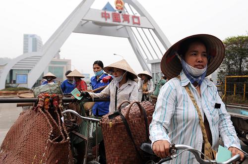 一些越南邊民在云南河口口岸準(zhǔn)備進(jìn)關(guān)(2009年3月21日攝)。 云南省邊境線全長4060公里,目前全省有20個口岸,其中國家一類口岸13個,國家二類口岸7個。這些口岸中對越南口岸4個,對老撾口岸1個,對緬甸口岸11個。經(jīng)過多年建設(shè),云南口岸查驗(yàn)設(shè)施和配套設(shè)施正在逐步完善,瑞麗等14個口岸聯(lián)檢樓、河口等10個口岸國門以及盈江等10個口岸查驗(yàn)貨場已投入使用。云南省商務(wù)廳表示,為促進(jìn)云南口岸建設(shè)的通關(guān)便利化,提速中國——東盟貿(mào)易區(qū)建成后貿(mào)易往來,我國已加大對云南口岸的資金支持和政策扶持。從2009年起,4年內(nèi)云南省將以每年不少于2.2億元人民幣的資金,投入口岸建設(shè)。 新華社記者 藺以光 攝