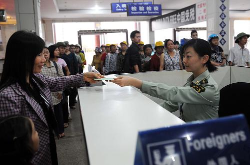 邊檢人員在云南河口口岸為邊民辦理入關(guān)手續(xù)(2009年3月21日攝)。 云南省邊境線全長4060公里,目前全省有20個口岸,其中國家一類口岸13個,國家二類口岸7個。這些口岸中對越南口岸4個,對老撾口岸1個,對緬甸口岸11個。經(jīng)過多年建設(shè),云南口岸查驗(yàn)設(shè)施和配套設(shè)施正在逐步完善,瑞麗等14個口岸聯(lián)檢樓、河口等10個口岸國門以及盈江等10個口岸查驗(yàn)貨場已投入使用。云南省商務(wù)廳表示,為促進(jìn)云南口岸建設(shè)的通關(guān)便利化,提速中國——東盟貿(mào)易區(qū)建成后貿(mào)易往來,我國已加大對云南口岸的資金支持和政策扶持。從2009年起,4年內(nèi)云南省將以每年不少于2.2億元人民幣的資金,投入口岸建設(shè)。 新華社記者 藺以光 攝