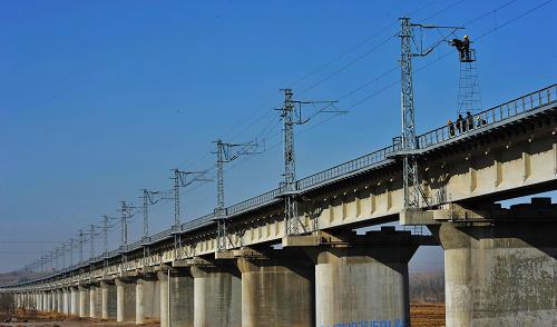 太中銀鐵路建設(shè)進(jìn)入最后沖刺階段 工人在太中銀鐵路寧夏中衛(wèi)大橋上架設(shè)電線(11月25日攝)。 投資超過(guò)300億元、全長(zhǎng)940多公里的一條橫貫晉、陜、寧三省區(qū),穿越崇山峻嶺的太原至寧夏中衛(wèi)、銀川鐵路(簡(jiǎn)稱“太中銀鐵路”),經(jīng)過(guò)4年多的建設(shè),目前進(jìn)入最后的施工階段。這是我國(guó)實(shí)施西部大開發(fā)戰(zhàn)略和中部崛起戰(zhàn)略的重點(diǎn)工程,計(jì)劃于2010年建成。這條鐵路的建設(shè)對(duì)提高寧夏、山西及沿線地區(qū)經(jīng)濟(jì)社會(huì)發(fā)展,加強(qiáng)東西部地區(qū)的經(jīng)濟(jì)聯(lián)系具有重要意義。 新華社記者劉泉龍攝