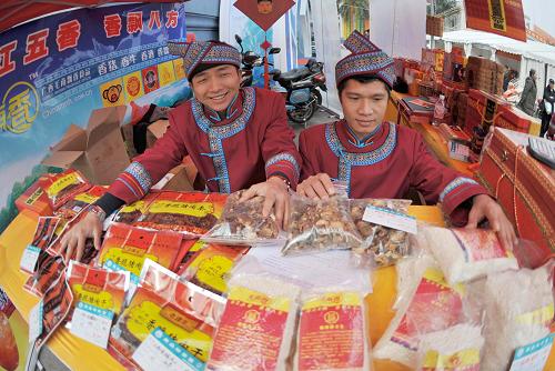 1月12日,在廣西南寧市廣西展覽館,來自環(huán)江毛南族自治縣的毛南族同胞在推介毛南“五香”系列品牌特產(chǎn)。新華社記者 周華 攝