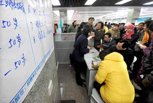 1月13日,一家對(duì)應(yīng)聘人員年齡放寬到50歲的用工單位攤點(diǎn)前,聚集了許多求職者。新華社記者 王頌 攝