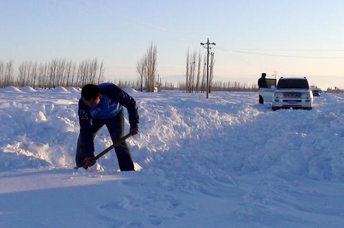 1月21日,過往群眾正在清理道路積雪。新華社記者 關(guān)俏俏 攝