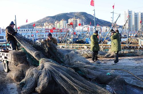 1月21日,漁民在大連市旅順口區(qū)龍王塘漁港碼頭整理網(wǎng)具。新華社發(fā)(呂文正 攝)