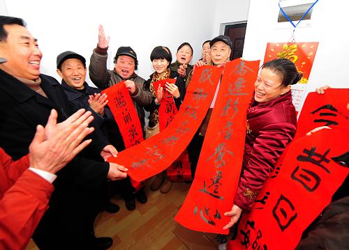1月26日,廉租房租戶劉滿紅(右一)剛搬進(jìn)新居,百步亭社區(qū)的街坊們紛紛前來祝賀,社區(qū)的書法愛好者還給她送來親手書寫的春聯(lián)。當(dāng)日,武漢市民劉滿紅一家三口搬進(jìn)了百步亭悅秀苑的廉租房,這套兩室一廳的住房使用面積37平方米,每月租金27元。劉滿紅一家是這個(gè)社區(qū)搬進(jìn)入住的首戶廉租房住戶。湖北省武漢市最大的保障性住房小區(qū)百步亭悅秀苑、景蘭苑位于市中心二環(huán)和三環(huán)之間的中心城區(qū),總建筑面積46萬平方米,包括5263套經(jīng)濟(jì)適用房和194套廉租房,2009年底該小區(qū)啟動(dòng)交房,5457戶住房困難家庭領(lǐng)到了新房鑰匙。新華社記者 程敏 攝